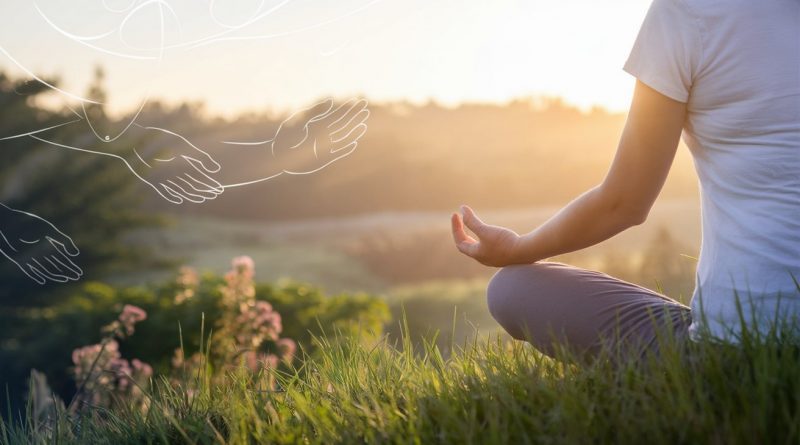 A serene scene of a person sitting cross-legged on a grassy hill at sunrise, meditating with hands resting on knees in a gesture of openness. The image features warm sunlight, lush green surroundings, and subtle outlines of supportive hands in the background, symbolising balance and connection.